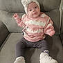 baby, child, clothing, comfortable, couch, cozy, cute, footwear, headband, indoor, infant, leggings, person, pink_sweater, playful, seated, smiling, stars, tongue_out, white_shoes