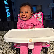 Akiriya joined the competition — help win amazing prizes! baby, child, cute, face, floor_lamp, footwear, furniture, granite_countertop, happy, high_chair, home, indoor, infant, person, pink_clothing, seat, smiling, table, television, window