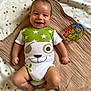 baby, smiling, onesie, toy, blanket, star_pattern, infant, cute, happy, lying_down, colorful, plastic_ball, child, playful, indoors, soft_texture, toddler, cheerful, face, small