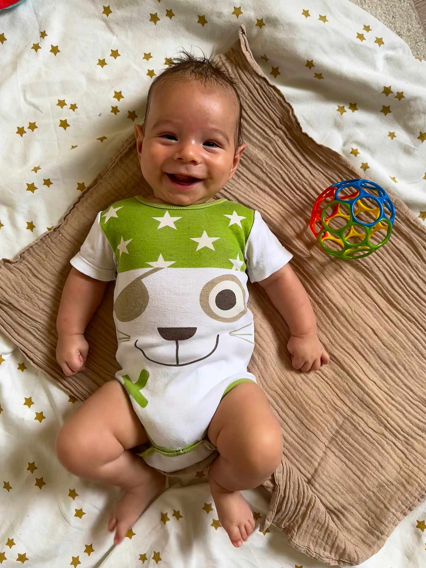 Lilian participe au concours pour gagner de l'argent avec cette photo : baby, smiling, onesie, toy, blanket, star_pattern, infant, cute, happy, lying_down, colorful, plastic_ball, child, playful, indoors, soft_texture, toddler, cheerful, face, small