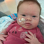 Ryleigh joined the competition — help win amazing prizes! baby, infant, nasal_tube, medical, hospital, pink_shirt, fruit_embroidery, hand, face, eyes, blanket, hospital_room, curly_hair, close_up, patient, child, healthcare, newborn, toddler, person