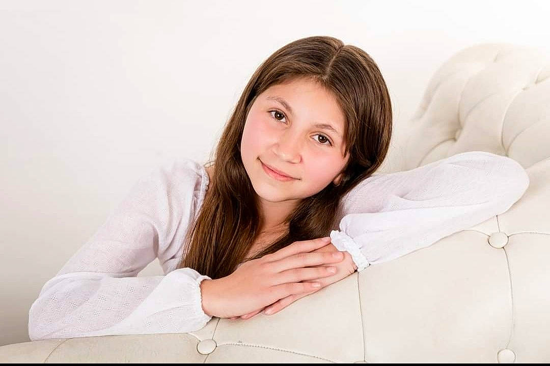 Kelsey joined the competition — help win amazing prizes! black_hair, brown_hair, collar, comfort, couch, ear, elbow, event, eyebrow, eyelash, face, flash_photography, gesture, happy, human_body, joy, linens, lip, neck, person