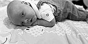 Louie is registered to the contest to win money with this photo: baby, infant, child, blanket, denim, overall, white_shirt, face, eyes, lying_down, curious, monochrome, black_and_white, soft_light, pattern, cute, peaceful, portrait, young, indoors