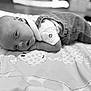 baby, infant, child, blanket, denim, overall, white_shirt, face, eyes, lying_down, curious, monochrome, black_and_white, soft_light, pattern, cute, peaceful, portrait, young, indoors