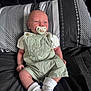 Louie is registered to the contest to win money with this photo: baby, infant, pacifier, overalls, socks, pillow, bed, blanket, clothing, person, child, cute, sleepwear, resting, young, indoor, portrait, newborn, head, face