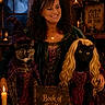 woman, cat, cats, witch, costume, halloween, fantasy, magic, spellbook, candles, indoors, portrait, black_cat, gray_cat, pointy_hat, long_hair, dress, dark, decor, smiling