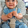 baby, blue_dress, child, close_up, cute, eyes, face, food_crumbs, furniture, hands, happy, high_chair, home, indoor, person, plush_chair, portrait, seat_belt, smiling, young_child