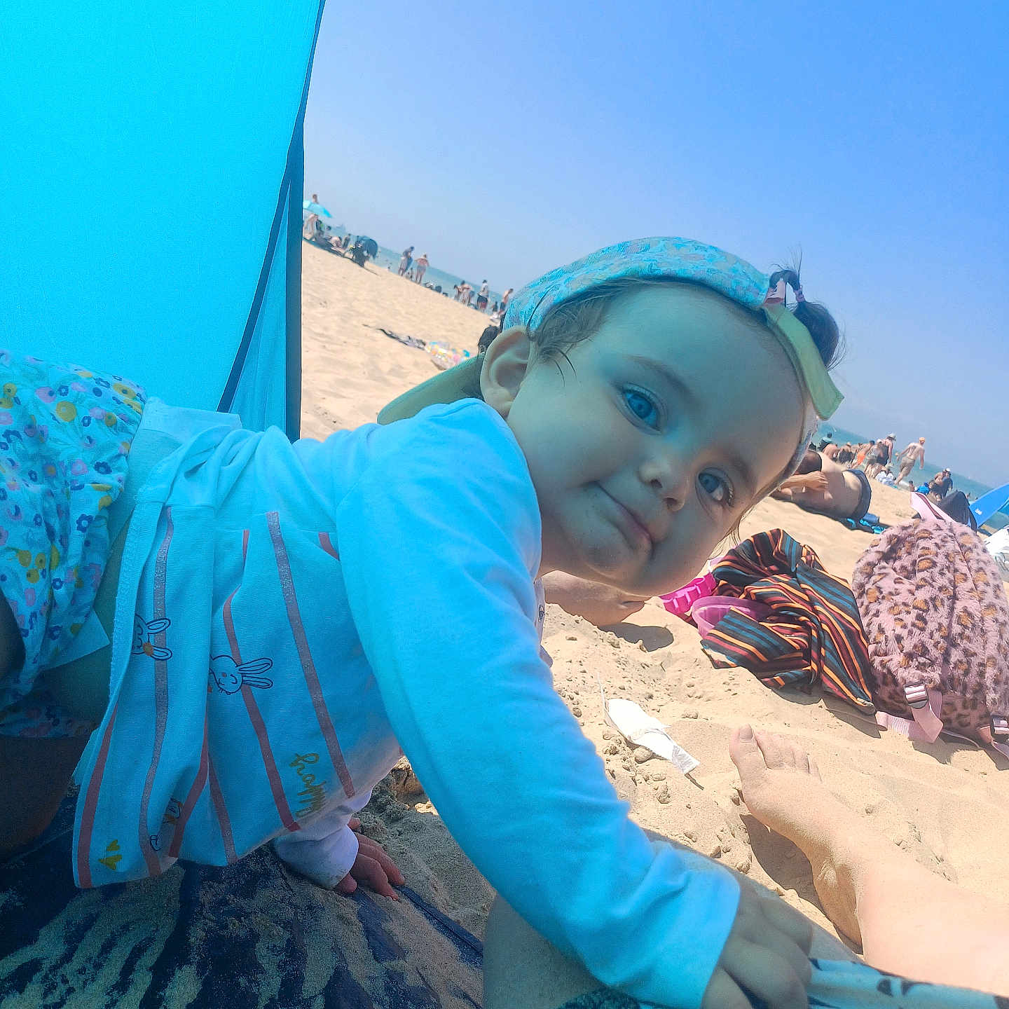 Lucy a rejoint le concours — aidez-le/la à gagner de superbes lots ! beach, blue_sky, cap, child, clothing, foot, holiday, mat, outdoor, pattern, people, playful, relaxation, sand, smiling, summer, sunlight, sunshade, toddler, vacation