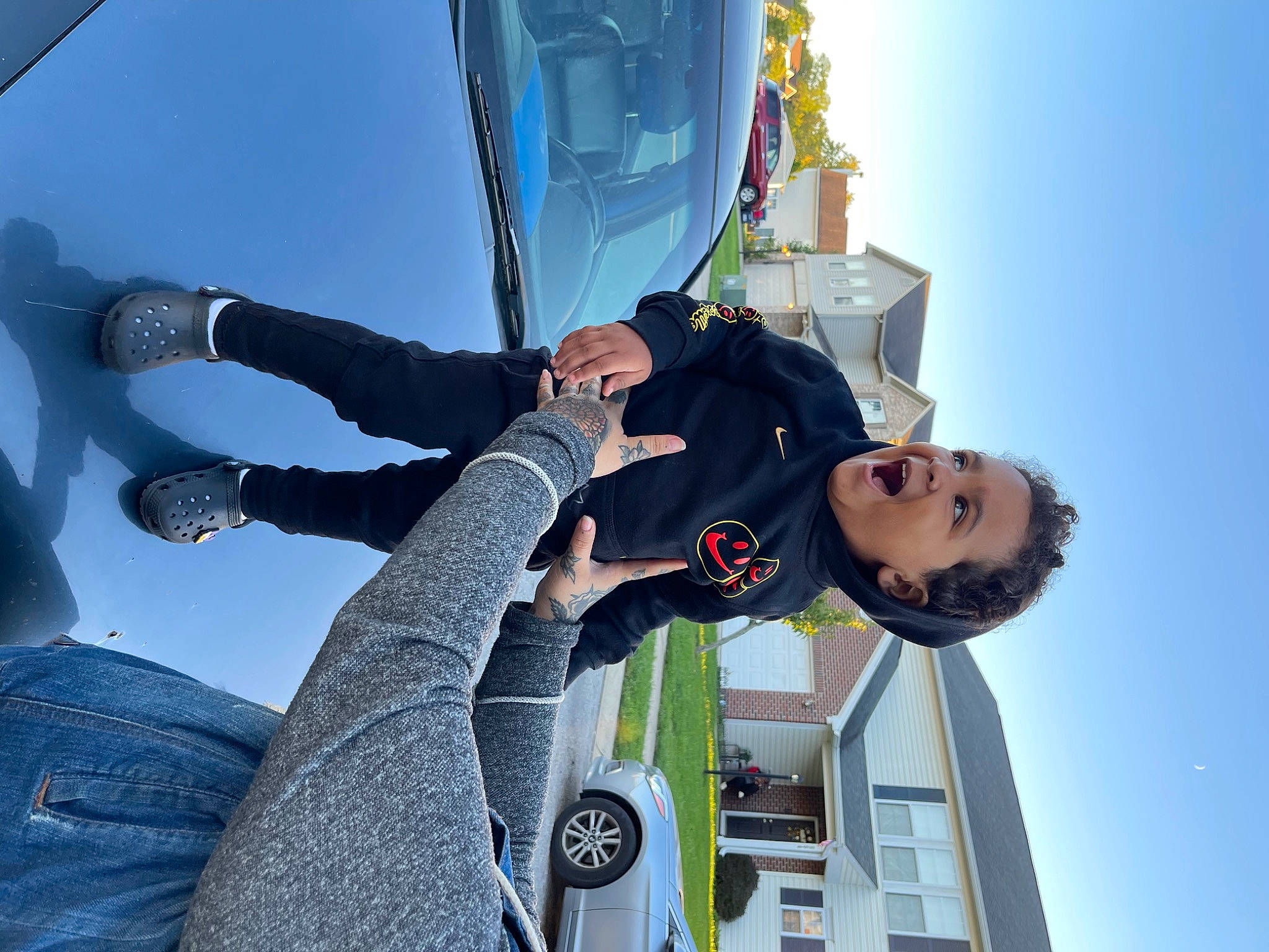 Kobe is registered to the contest to win money with this photo: aerospace_engineering, air_sports, automotive_exterior, car, daytime, electric_blue, eyewear, fun, gesture, glove, leisure, parachuting, person, personal_protective_equipment, recreation, sky, tire, travel, vehicle, vehicle_door