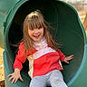 child, girl, slide, playground, outdoor, smile, happy, fall, leaves, red_jacket, leggings, play, fun, activity, park, nature, daylight, casual_clothing, young, joy