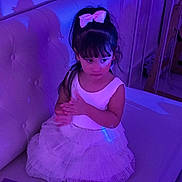 Elena is registered to the contest to win money with this photo: child, girl, toddler, portrait, sitting, couch, dress, white_dress, bow, hair_bow, long_hair, bangs, face, indoor, furniture, home, purple_lighting, blue_lighting, fashion, smiling