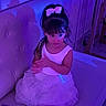 child, girl, toddler, portrait, sitting, couch, dress, white_dress, bow, hair_bow, long_hair, bangs, face, indoor, furniture, home, purple_lighting, blue_lighting, fashion, smiling