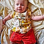 baby, blanket, casual, child, clothing, comfort, cute, fabric, face, happy, indoors, infant, lying_down, person, relaxed, shirt, shorts, skin, smiling, young