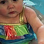 Alaska is registered to the contest to win money with this photo: arm, baby, child, close_up, cute, droplets, eyes, face, gold_strap, infant, pool, portrait, rainbow, rosy_cheeks, ruffle, splashing, summer, swimsuit, water, wet_skin