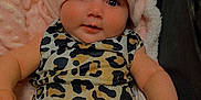 Alaska is registered to the contest to win money with this photo: baby, blanket, bow, child, chubby_cheeks, close_up, clothing, cozy, cute, eyes, hat, headwear, infant, leopard_print, onesie, pink, plush_toy, portrait, smiling, stroller