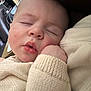 baby, infant, sleeping, close_up, face, cheek, lips, hand, sweater, knitwear, cozy, nap, resting, portrait, indoor, couch, furniture, soft_texture, peaceful, skin