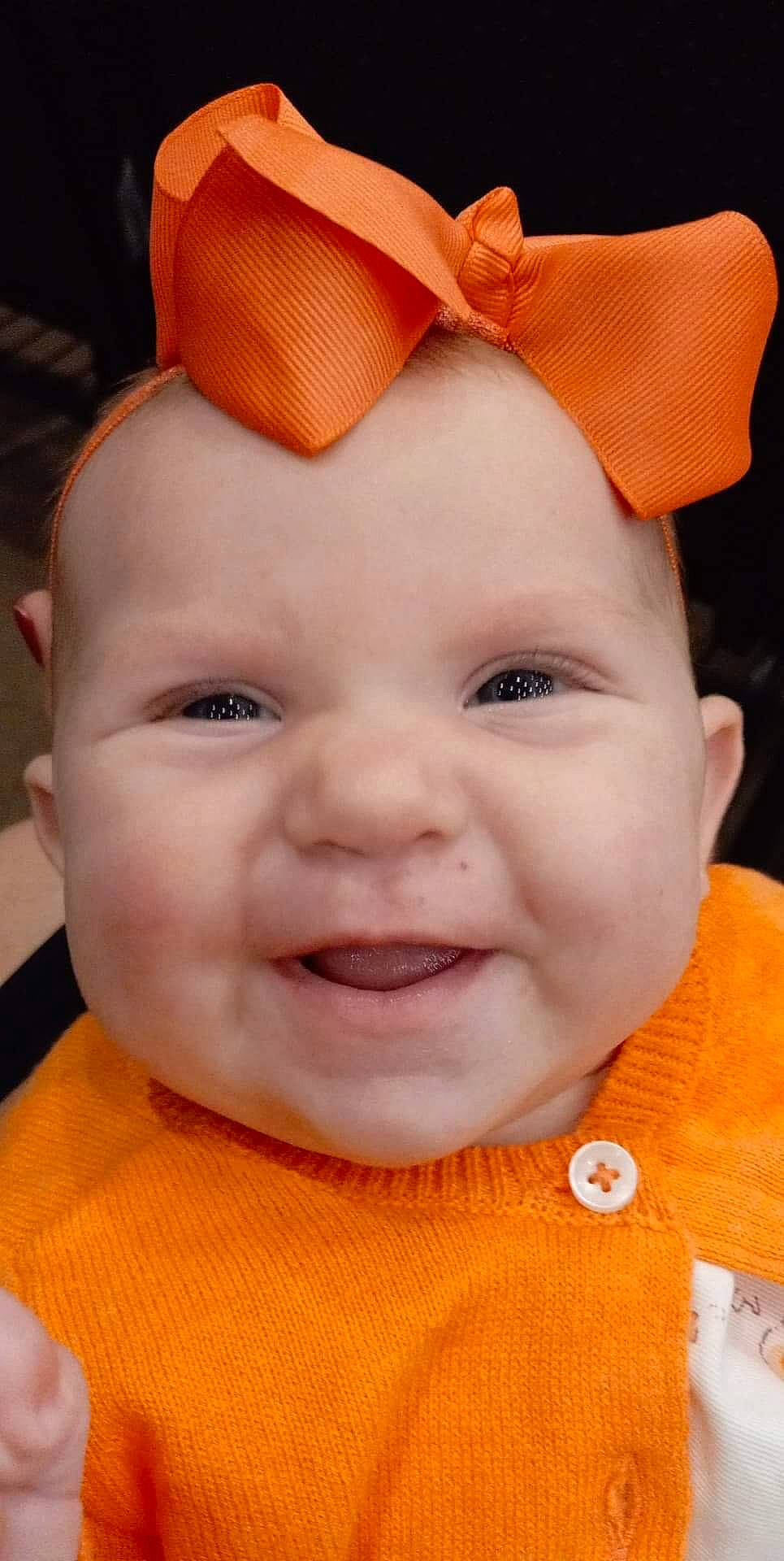 Bailey is registered to the contest to win money with this photo: baby, cheek, chin, ear, eye, eyebrow, face, facial_expression, forehead, happy, head, lip, nose, orange, person, product, skin, smile, textile, white