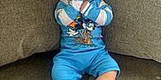 Ezra is registered to the contest to win money with this photo: baby, child, blue_outfit, hat, thumb_sucking, couch, sofa, plush_toy, indoor, happy, cute, person, face, feet, clothing, sitting, infant, home, smile, relaxed