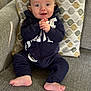 baby, infant, smiling, happy, clothing, onesie, couch, pillow, patterned_pillow, indoor, child, cute, hands, feet, face, person, seated, home, cozy, texture