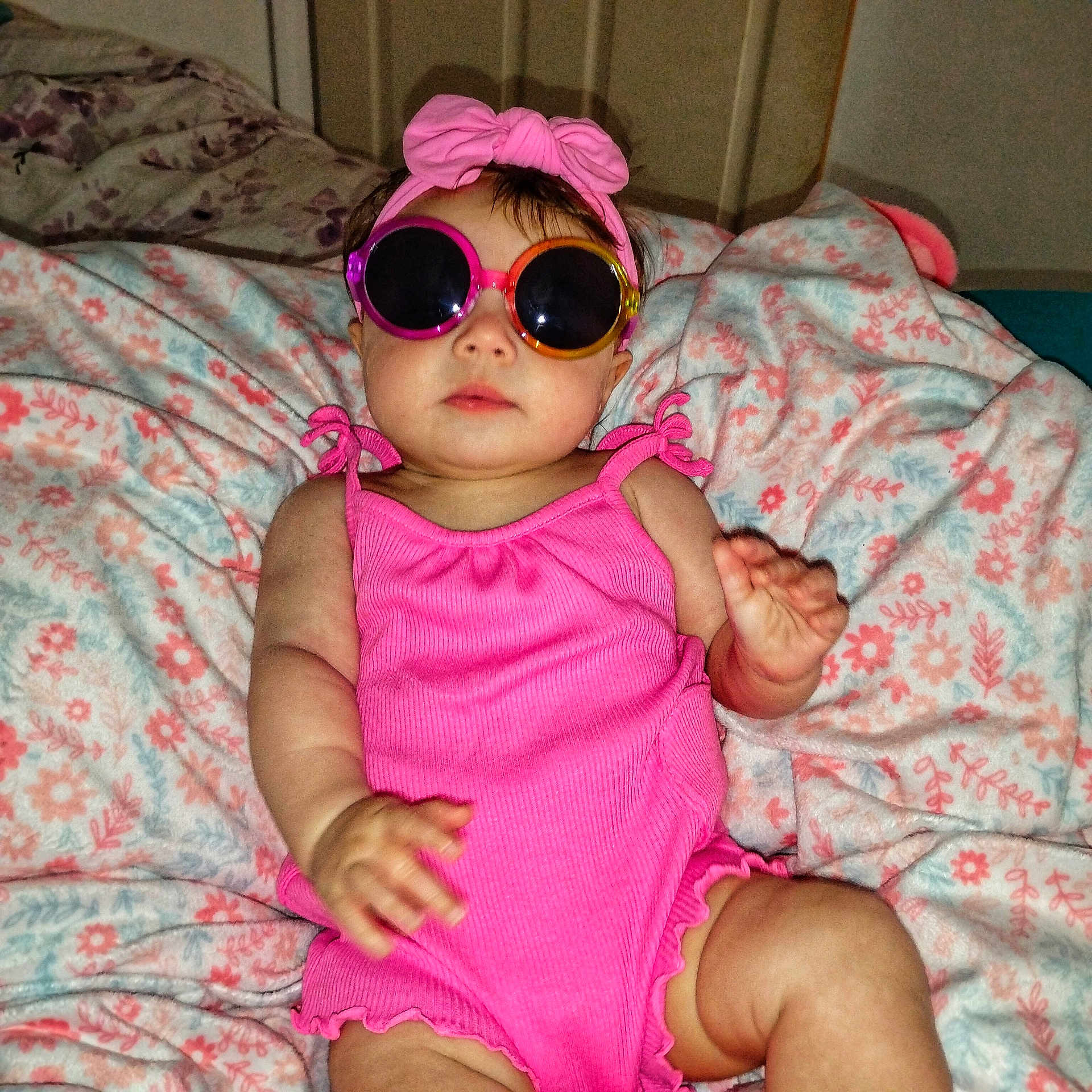 Brayleigh is registered to the contest to win money with this photo: accessory, baby, blanket, child, clothing, cute, expression, face, fashion, flower_pattern, hand, headband, indoors, infant, person, pink, portrait, relaxing, skin, sunglasses