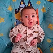 Amir is registered to the contest to win money with this photo: baby, baby_chair, cartoon_characters, child, clothing, comfort, cute, expression, face, home, indoor, infant, monkey_pattern, onesie, person, portrait, seated, stars, toy, young