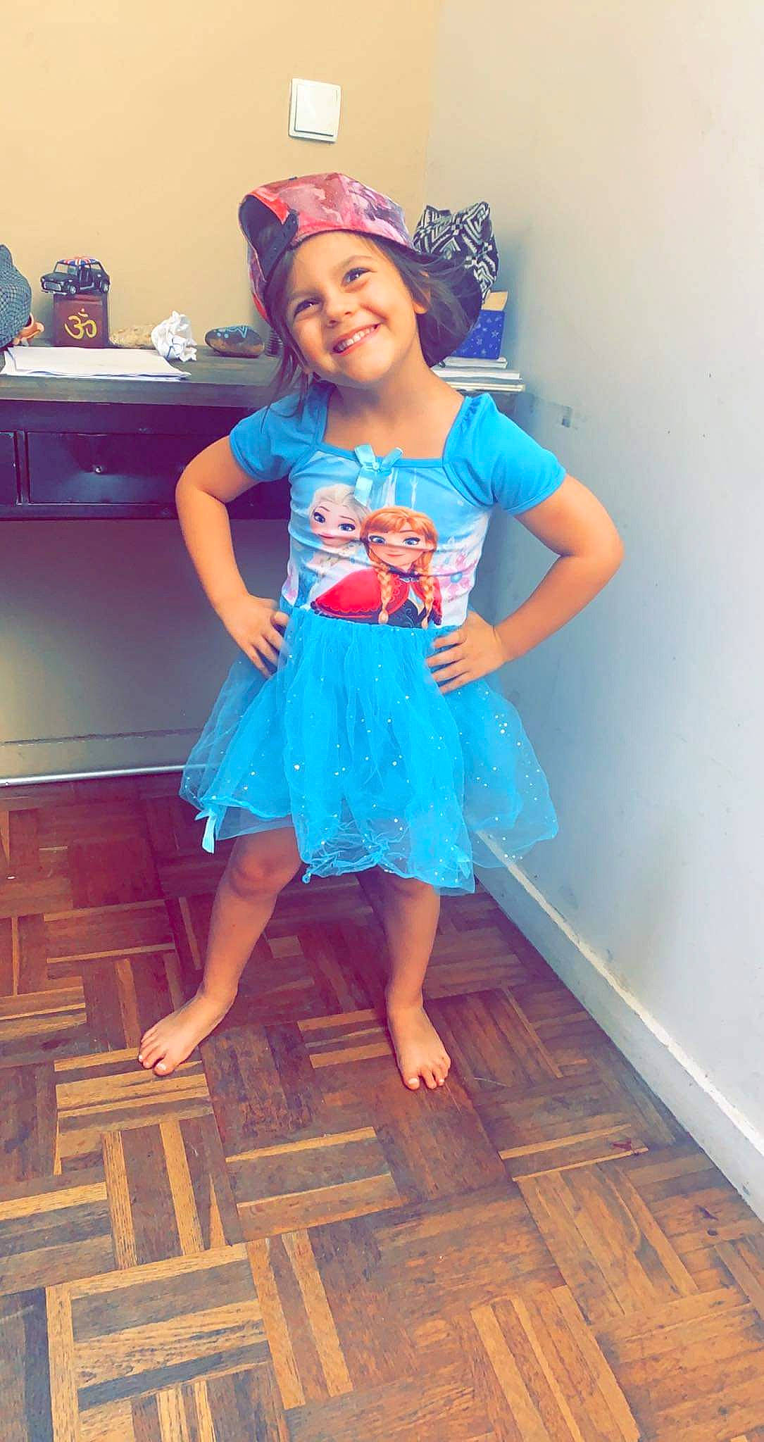 Lyah a rejoint le concours — aidez-le/la à gagner de superbes lots ! baby_toddler_clothing, day_dress, dress, electric_blue, fashion_design, flooring, happy, hardwood, headwear, joy, leg, magenta, one_piece_garment, person, pink, sleeve, smile, standing, t_shirt, thigh