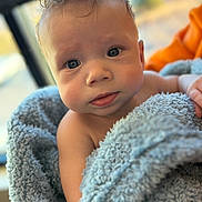 Christian is registered to the contest to win money with this photo: baby, blanket, blue, child, closeup, curly_hair, cute, expression, eyes, face, fluffy, hand, indoors, infant, portrait, skin, soft_texture, toddler, wrapped, young
