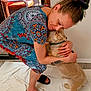 Copper is registered to the contest to win money with this photo: woman, dog, hugging, indoor, dress, patterned_clothing, slippers, tattoo, floor, door, glass_door, patio_furniture, cuddling, pet, animal, affection, casual, home, light, comfort
