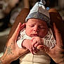 baby, newborn, sleeping, hands, tattoo, hat, clothing, infant, person, closeup, cute, soft_light, indoor, portrait, peaceful, cozy, skin, human, newborn_clothing, resting