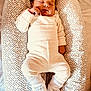 baby, newborn, sleeping, infant, pajamas, booties, baby_nest, cozy, patterned, soft, peaceful, child, indoors, resting, cute, portrait, small, hands, face, sleep