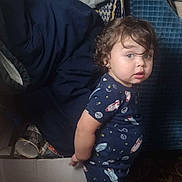 Swiss joined the competition — help win amazing prizes! toddler, child, indoor, pajamas, space_theme, curly_hair, box, blanket, can, carpet, person, standing, looking, furniture, home, casual, expression, barefoot, young_child, curious
