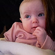 Chloe joined the competition — help win amazing prizes! baby, infant, face, hand, blanket, pink_clothing, portrait, curious, soft_texture, closeup, child, young, cute, cozy, indoors, person, skin, head, expression, warm