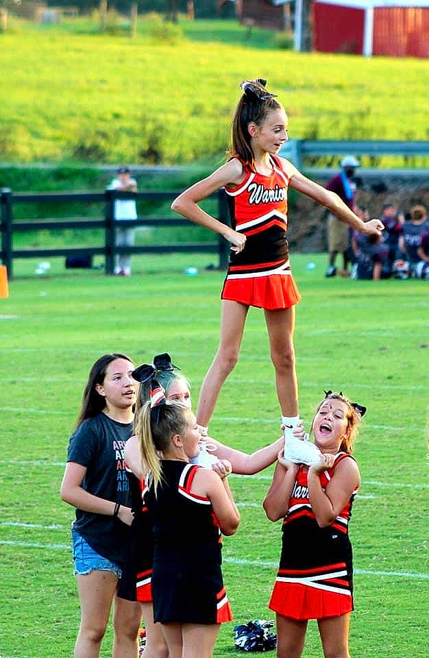 Bella is registered to the contest to win money with this photo: ball_game, cheerleading_uniform, clothing, competition, competition_event, event, fun, grass, person, player, recreation, shorts, skort, smile, sports, sports_uniform, summer, team, thigh, tournament