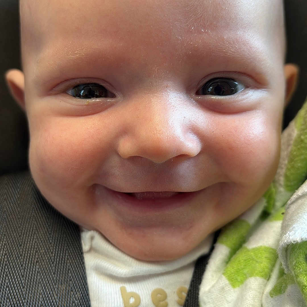 Buck joined the competition — help win amazing prizes! baby, blanket, car_seat, child, close_up, clothing, comfort, cute, expression, face, happy, head, human, infant, portrait, seatbelt, skin, smiling, toddler, young