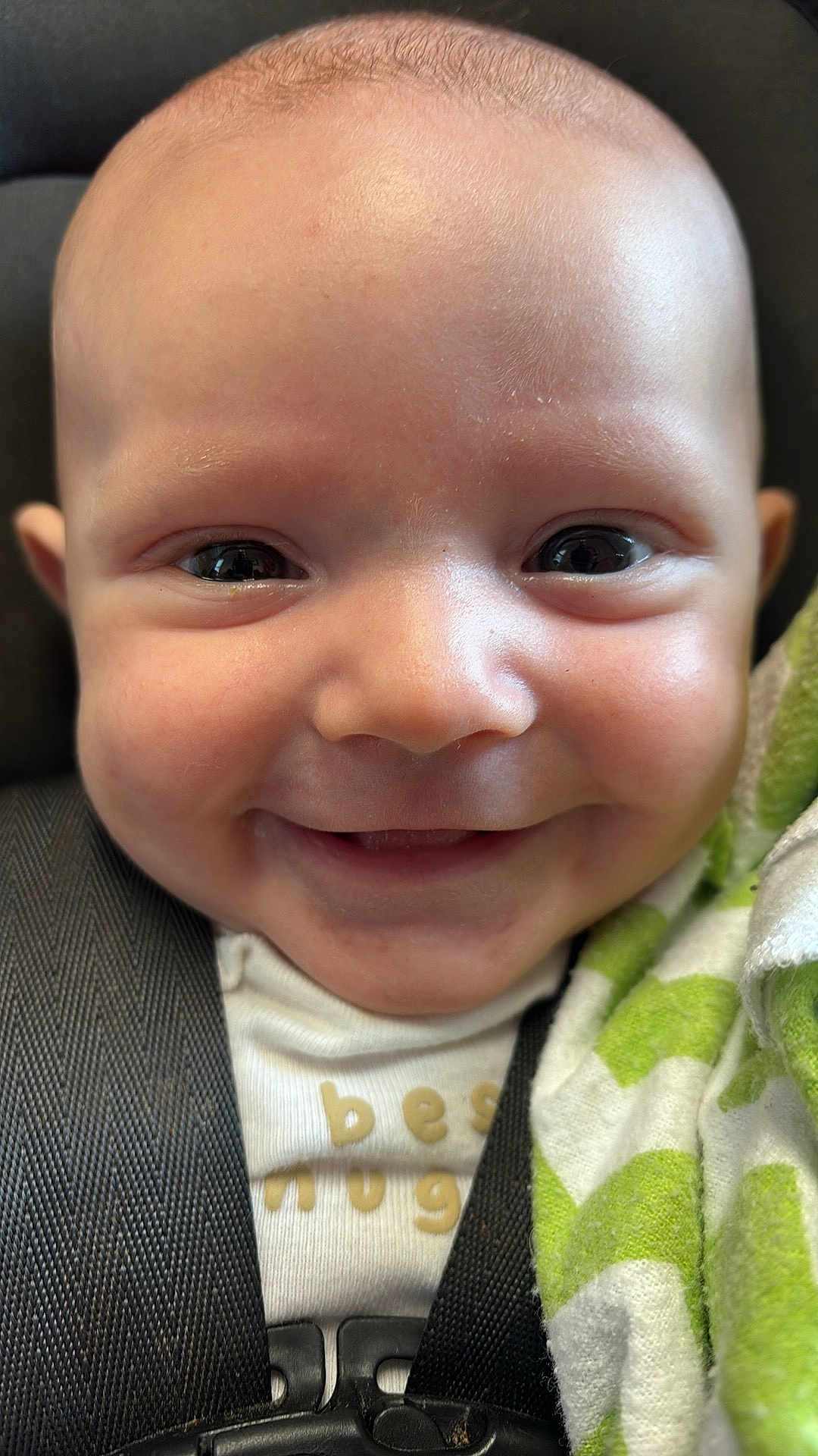 Buck joined the competition — help win amazing prizes! baby, smiling, face, close_up, car_seat, blanket, infant, happy, child, seatbelt, cute, portrait, clothing, human, young, toddler, skin, expression, head, comfort
