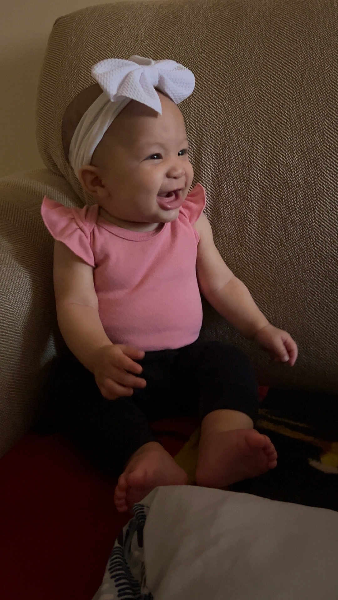 Xahya is registered to the contest to win money with this photo: baby, child, smiling, headband, pink_clothing, sitting, chair, indoor, happy, infant, barefoot, cute, portrait, young_child, toddler, person, one_person, head, face, furniture