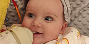 Ava participe au concours pour gagner de l'argent avec cette photo : baby, blanket, bottle, child, comfort, cute, face, feeding, happy, headwear, indoors, infant, onesie, plush_toy, rainbow_pattern, sleepwear, smiling, soft_texture, toy, warm