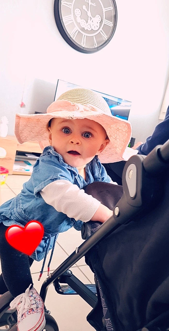Tahïs participe au concours pour gagner de l'argent avec cette photo : baby, baby_carriage, baby_products, child, clock, comfort, electric_blue, fashion_accessory, flooring, fun, happy, hat, headwear, home_appliance, leisure, person, recreation, shoulder, sitting, sun_hat