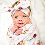 newborn, baby, infant, wrapped, blanket, headband, bow, floral, animal_print, cute, portrait, face, hands, closeup, soft, pink, white, skin, eyes, sleepy