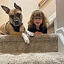 Rudy joined the competition — help win amazing prizes! animal, black_harness, brown_dog, carpet, child, curly_hair, cute, dog, friendship, glasses, hand, indoor, looking_at_camera, pet, railing, smile, stairs, together, wall, young_child