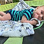Blake joined the competition — help win amazing prizes! baby, blanket, blue_clothing, child, curious, cute, face, fingers, foot, lying_down, outdoor, person, plush_blanket, portrait, resting, sitting, soft_texture, striped_clothing, trampoline, young_child