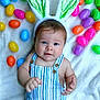 baby, child, bunny_ears, striped_overalls, easter_eggs, colorful, plastic_eggs, blanket, cute, infant, portrait, smiling, hands, blue_eyes, soft_texture, holiday, festive, spring, lying_down, playful