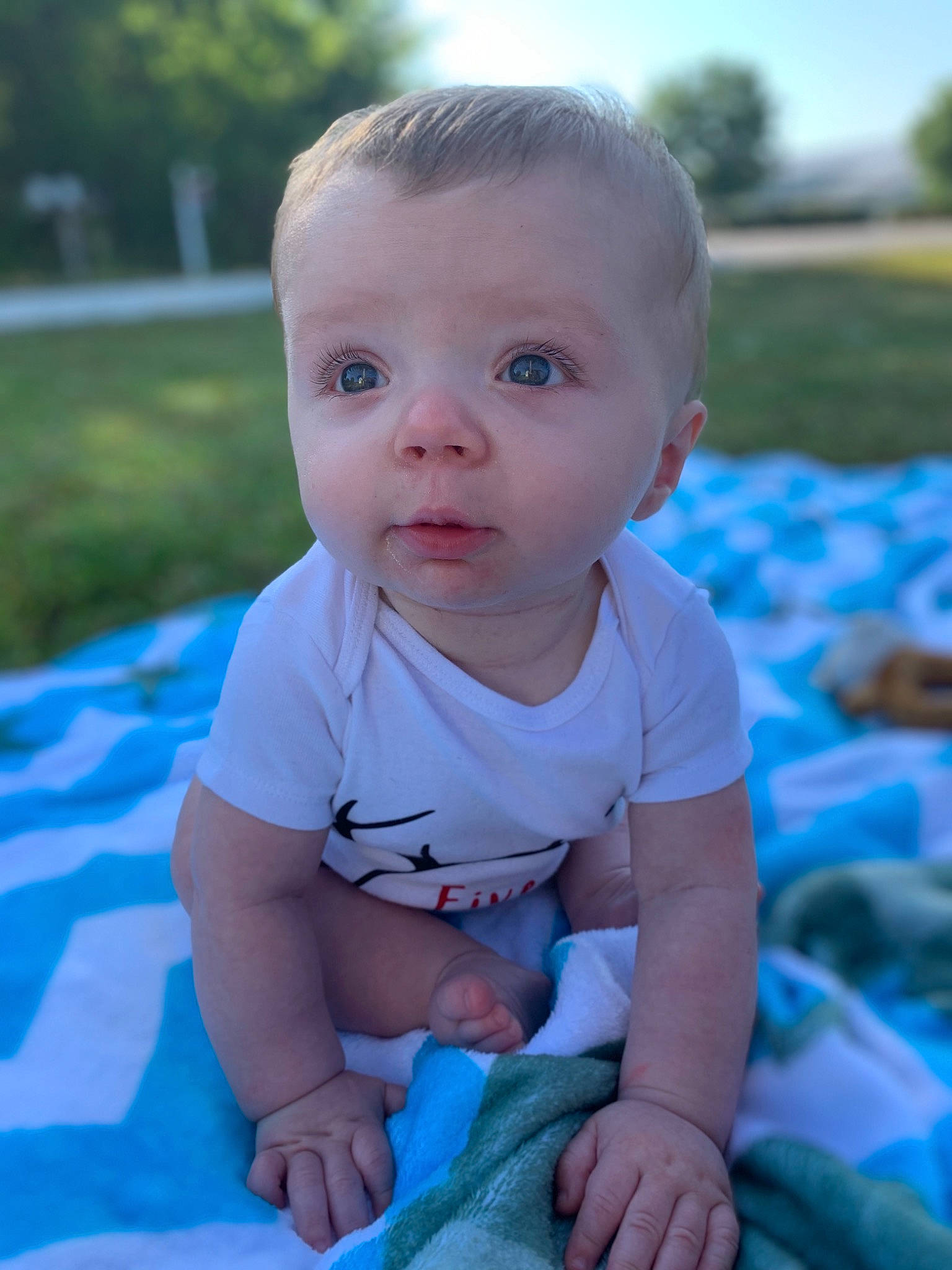 Edward is registered to the contest to win money with this photo: baby, blue, cheek, child, chin, eye, face, grass, head, lip, nose, people, person, product, sitting, skin, summer, toddler, tummy_time, vacation