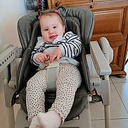 Charline a rejoint le concours — aidez-le/la à gagner de superbes lots ! baby, child, high_chair, pigtails, striped_sweater, polka_dot_pants, socks, smiling, indoor, wooden_cabinet, floor_tiles, seat_belt, baby_seat, face, person, cute, happy, hair_ties, furniture, tongue_out