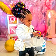 Ifunanya a rejoint le concours — aidez-le/la à gagner de superbes lots ! toddler, child, toy, birthday, balloons, pink, white_purse, smartwatch, boots, hair_clips, cornrows, indoor, car_toy, floor_tiles, party_decorations, blocks, colorful, cute, focused, celebration