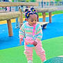 Ifunanya participe au concours pour gagner de l'argent avec cette photo : child, colorful_hair, cute, daylight, exploring, fashion, fence, greenery, hair_clips, outdoor, pastel_sweater, person, pink_pants, playground, pop_it_purse, rubber_surface, sneakers, toddler, wooden_bench, young_child