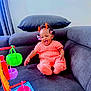 Ifunanya a rejoint le concours — aidez-le/la à gagner de superbes lots ! baby, child, colorful, couch, cute, fun, furniture, hair_accessories, happy, home, indoor, infant, knitted_outfit, orange_clothing, person, playful, portrait, sitting, smiling, toy