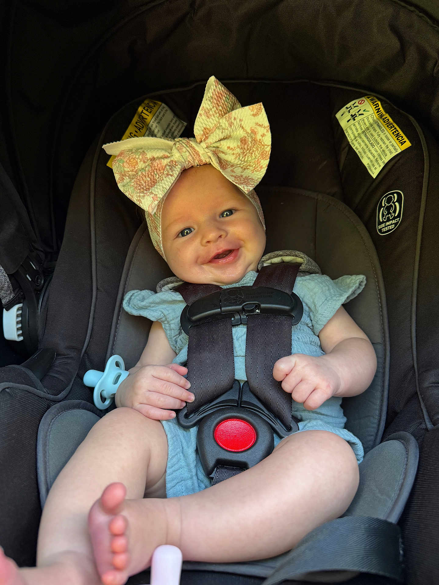 Mckenley joined the competition — help win amazing prizes! baby, car_seat, child, infant, smiling, bow, headwear, harness, safety, cute, hands, feet, blue_clothing, pacifier, seat, child_safety, portrait, indoor, happy, person