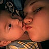 Daniel is registered to the contest to win money with this photo: baby, infant, adult, parent, cuddle, kiss, affection, portrait, close_up, bedtime, blanket, striped_clothing, sleepy, family, indoors, warm_lighting, selfie, tender, cheek_to_cheek, cozy