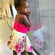 Keïline a rejoint le concours — aidez-le/la à gagner de superbes lots ! child, girl, reflection, window, pink_top, floral_skirt, sandals, earrings, curly_hair, hallway, floor, light, reflection_on_glass, standing, profile, thoughtful, indoor, young, person, casual_clothing
